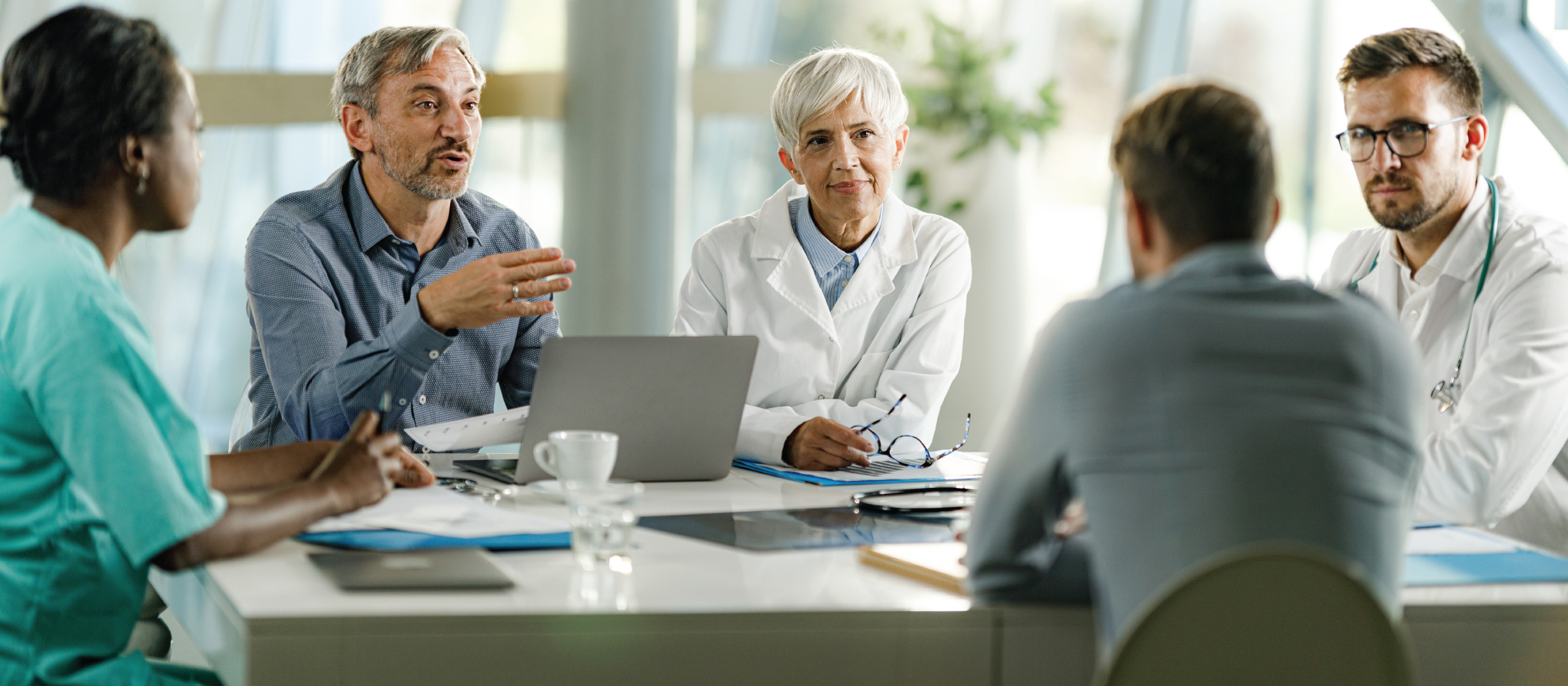 Team of doctors and businessmen communicating while having a meeting at doctor's office in the hospital.